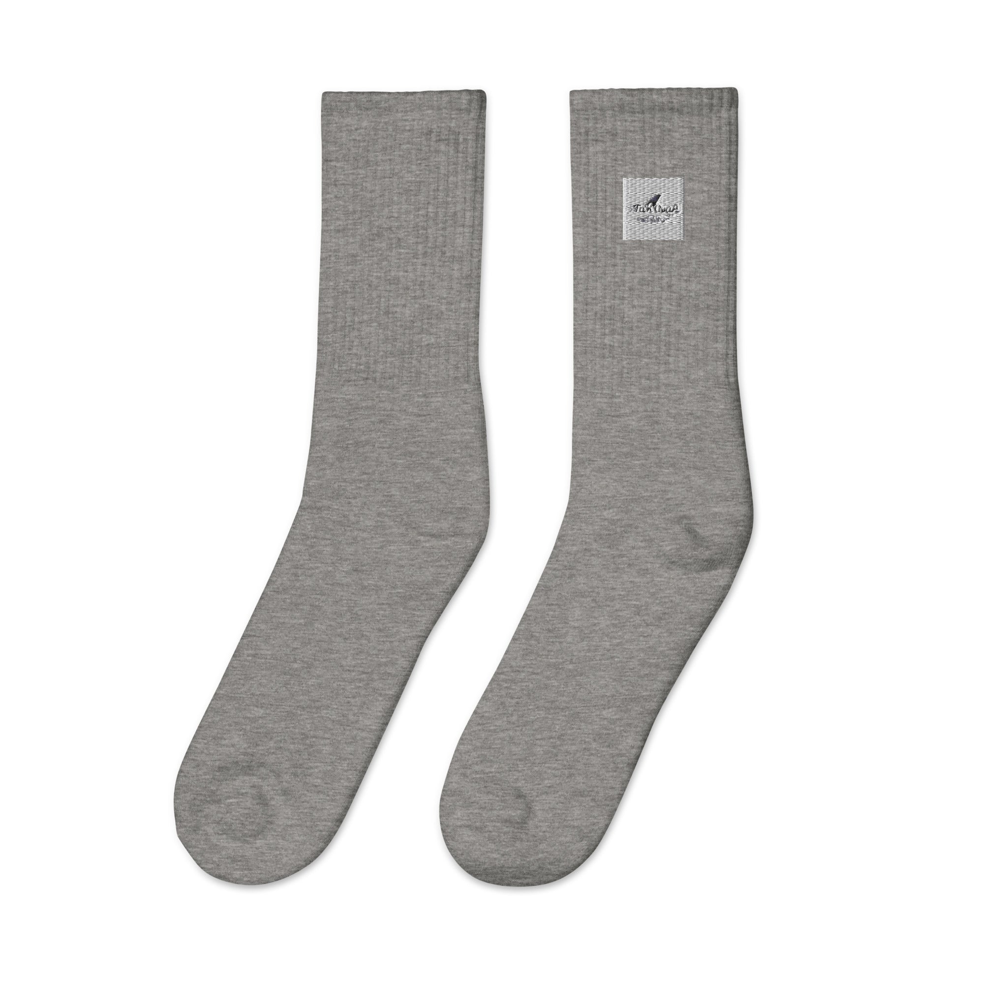 Pair of gray socks with a small logo on a white background